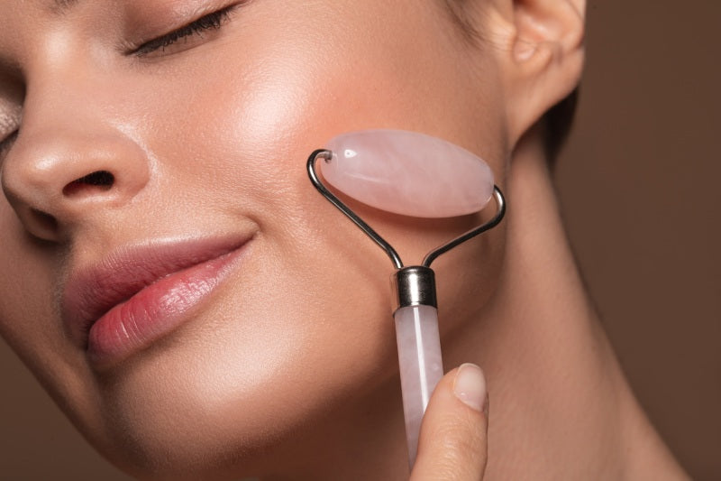 Woman using rose quartz facial roller on face