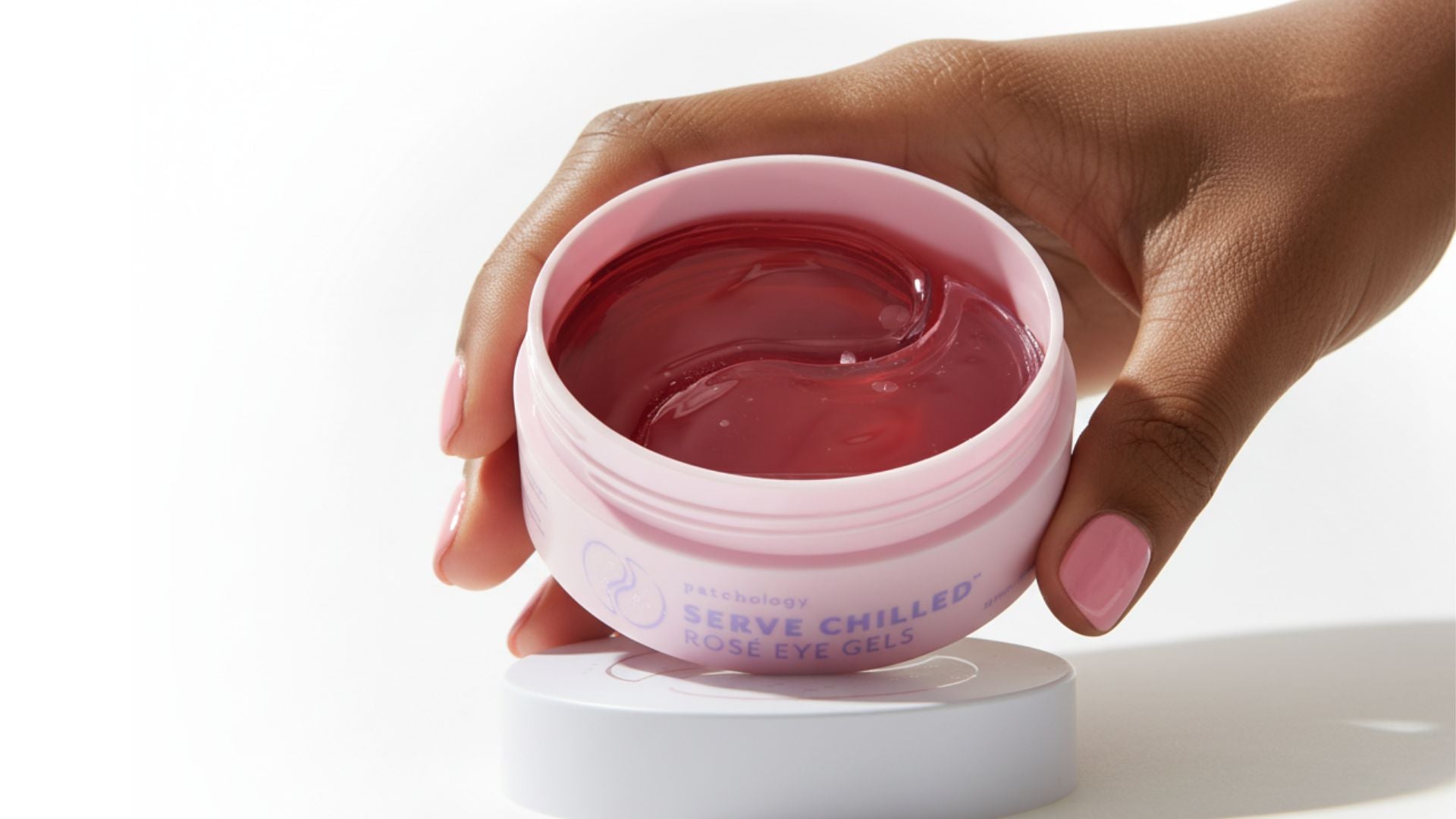 rose eye gels in hands close up on white background soft shadows