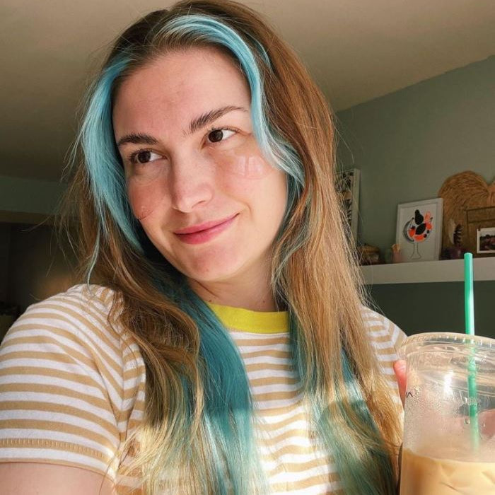 Woman holds a facial serum bottle containing probiotics