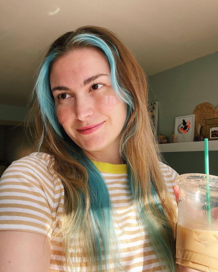 Woman holds a facial serum bottle containing probiotics