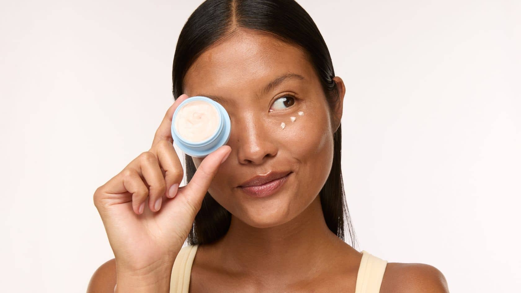 under eye cream woman applying bright white background peptides and caffeine
