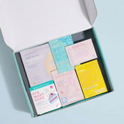Open box containing various colorful skincare patches on a light blue background