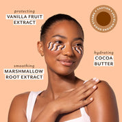 Woman applying cream to shoulder with text about vanilla fruit extract, cocoa butter, and marshmallow root extract on a peach background.