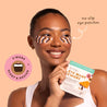 Woman wearing zebra-patterned eye patches with a product package in front of her.