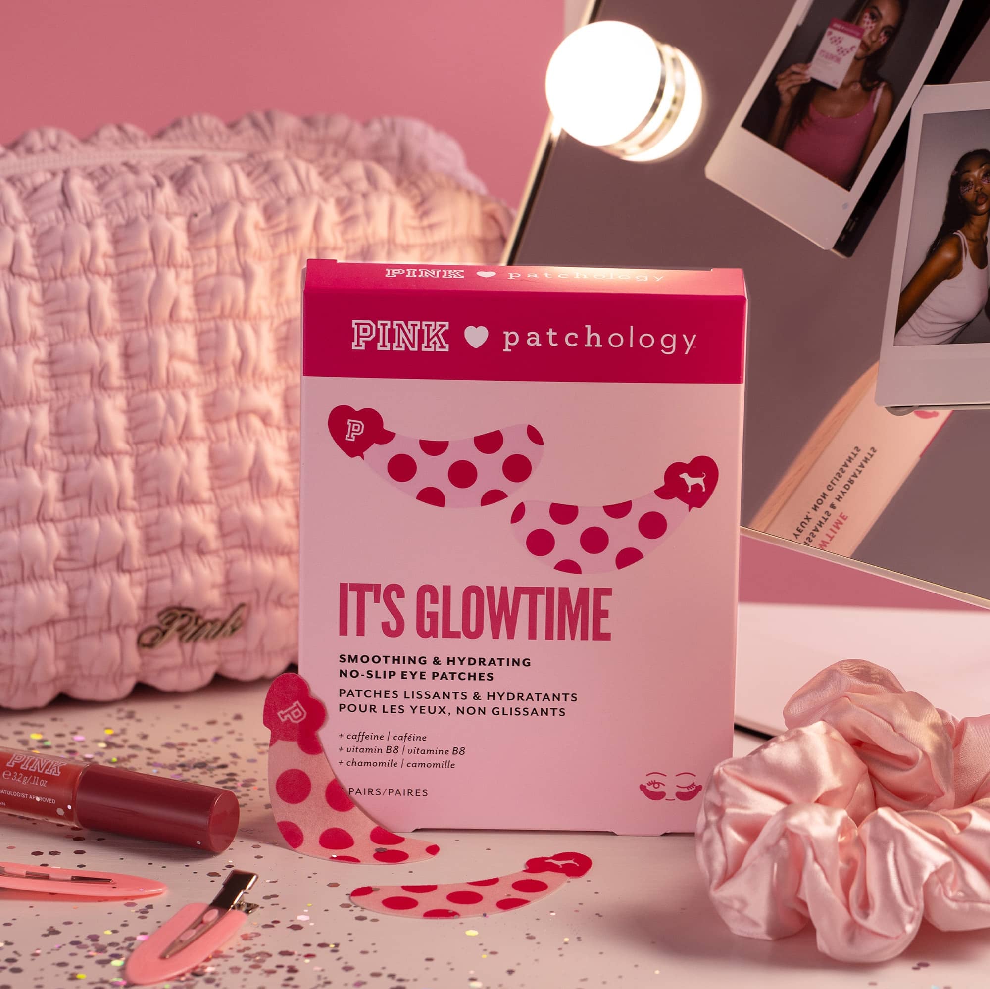 Pink patchology It's Glowtime smoothing and hydrating no slip eye patches in a pink box, styled on a pink desk with a pink scrunchie, lip product, and Polaroid photos.