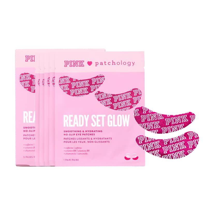 Five pink packets of PINK patchology Ready Set Glow no-look eye patches are arranged on a white background, with three matching patches fanned out to the right. The packets are light pink with dark pink text and graphics, and the patches are dark pink with white 'PINK' lettering.