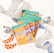 Patchology holiday-themed skincare product packaging with ribbons and ornaments on a white background