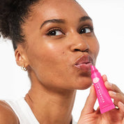 Woman applies Lip Service gloss to balm lip smoothing gloss to hydrate dry cracked lips