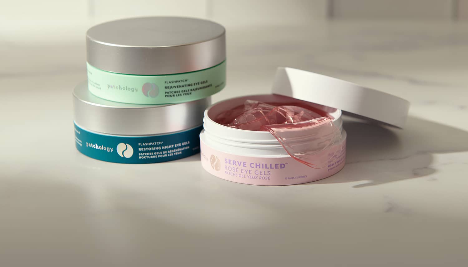 Three eye patch skincare jars with visible product on a light background