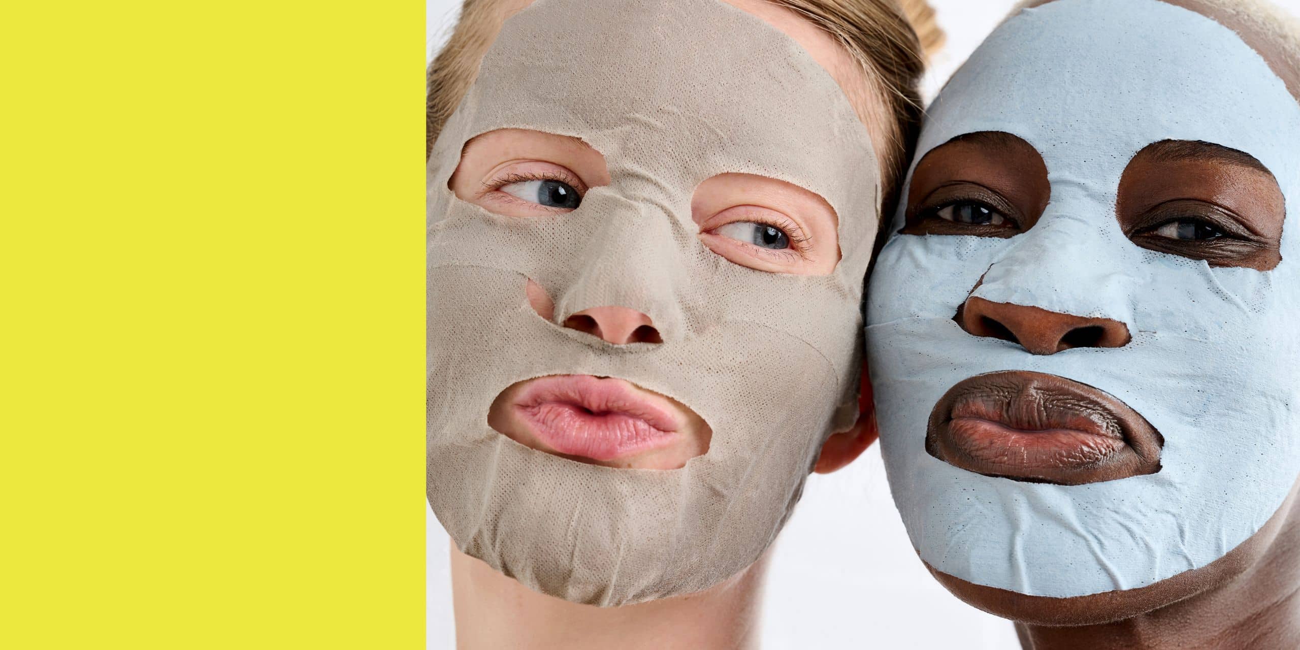 Two women wearing clay sheet masks, playful skincare routine with grey and blue masks on faces