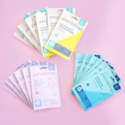 Collection of Patchology face mask packages on a pink background