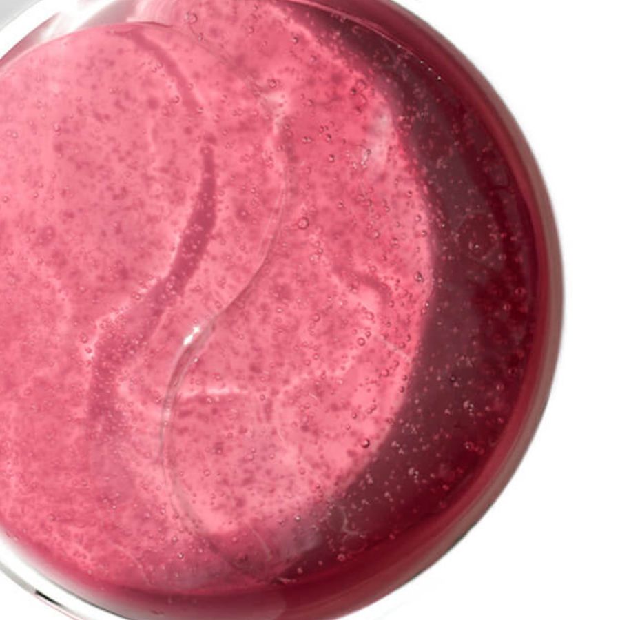 Pink shimmering hydrogel eye patches with a bubbly, translucent texture visible through a round clear container.